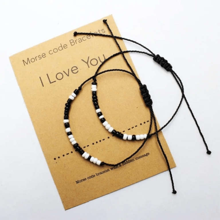 Des bracelets blanc et noir morse "I love you" pour amoureux posés sur une carte sur un fond blanc