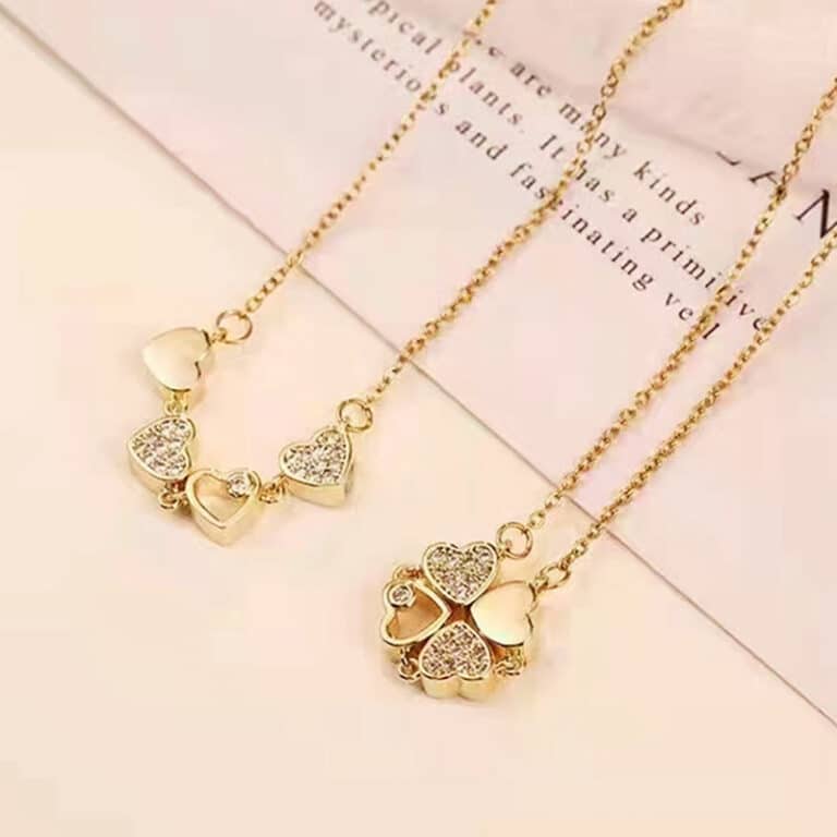 Collier trèfle coeur doré pour femmes devant un arrière plan beige