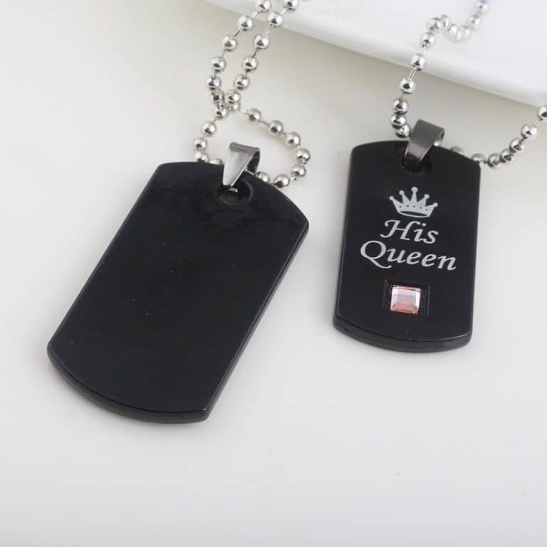 Deux Colliers de couple avec pendentifs noirs à gravure royal sur un support blanc