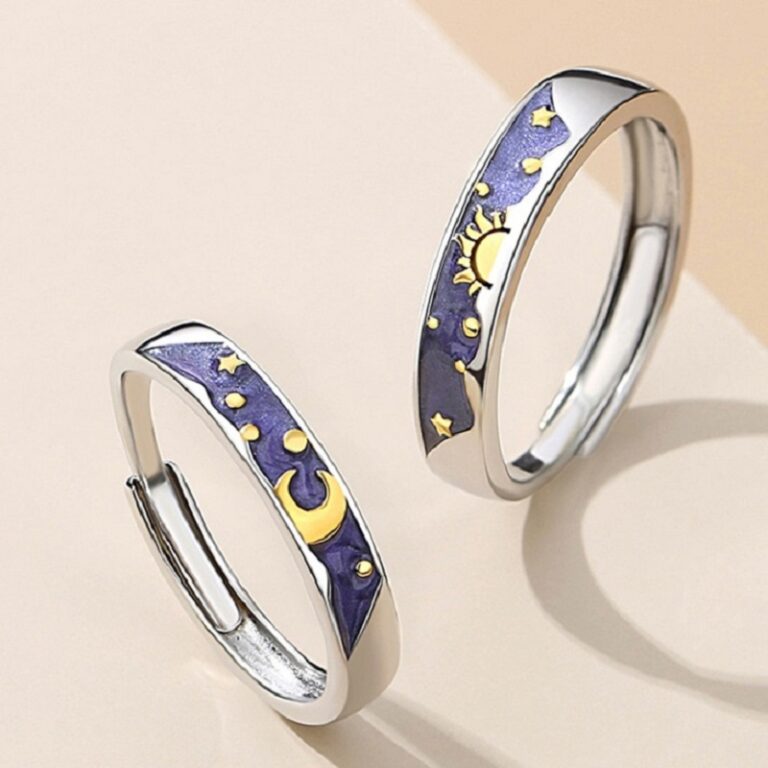 Deux bagues pour homme et femme en forme de soleil et de lune sur un fond beige