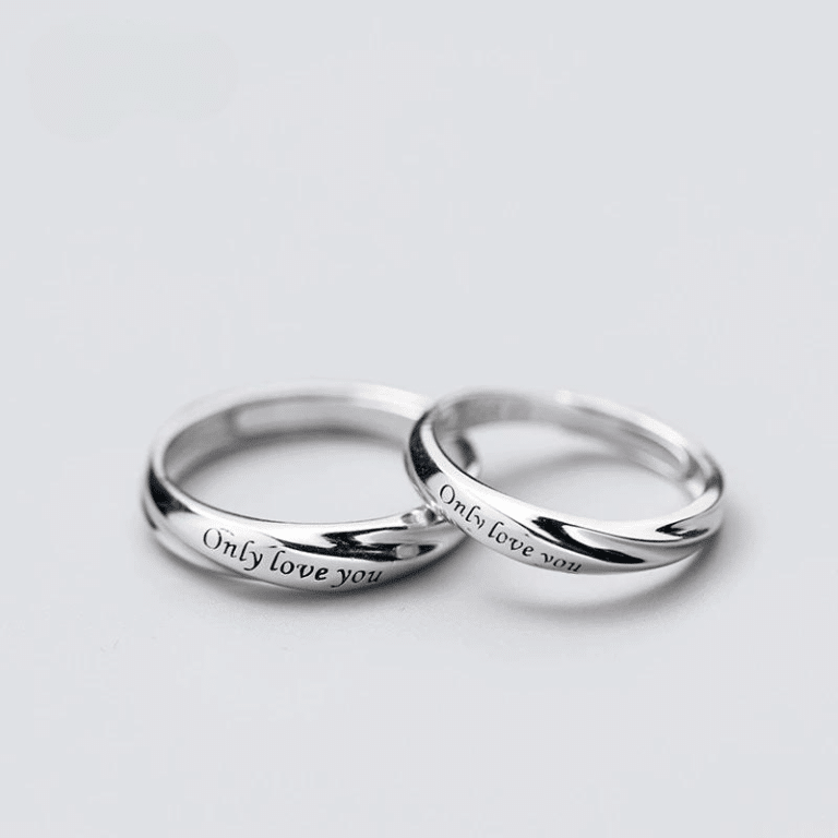 Ensemble de bagues avec lettres sculptées pour couple sur un fond blanc