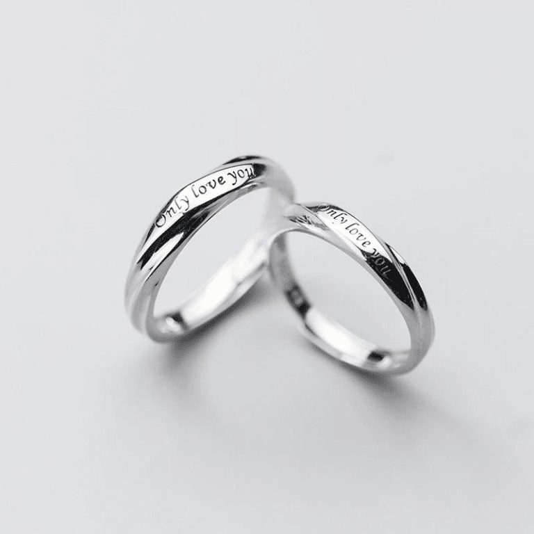 Ensemble de bagues avec lettres sculptées pour couple sur un fond blanc