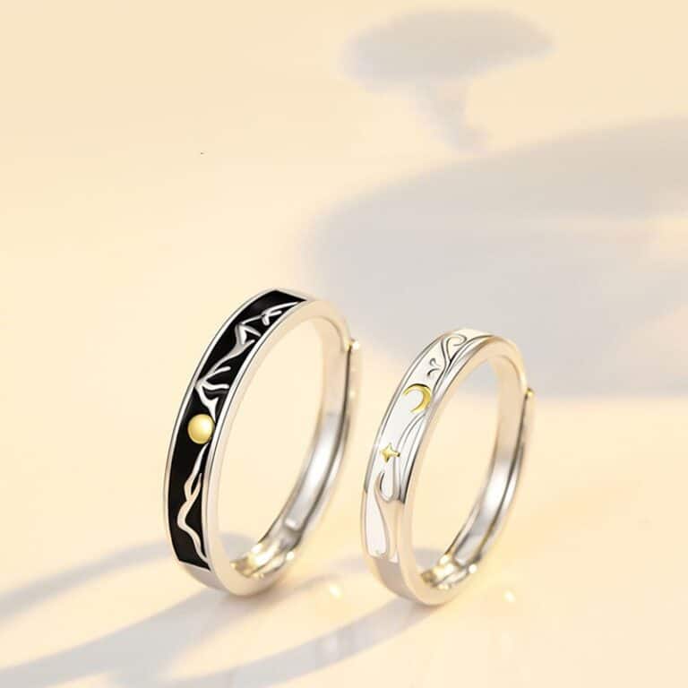 Un duo de bagues modernes pour couple sur un fond beige