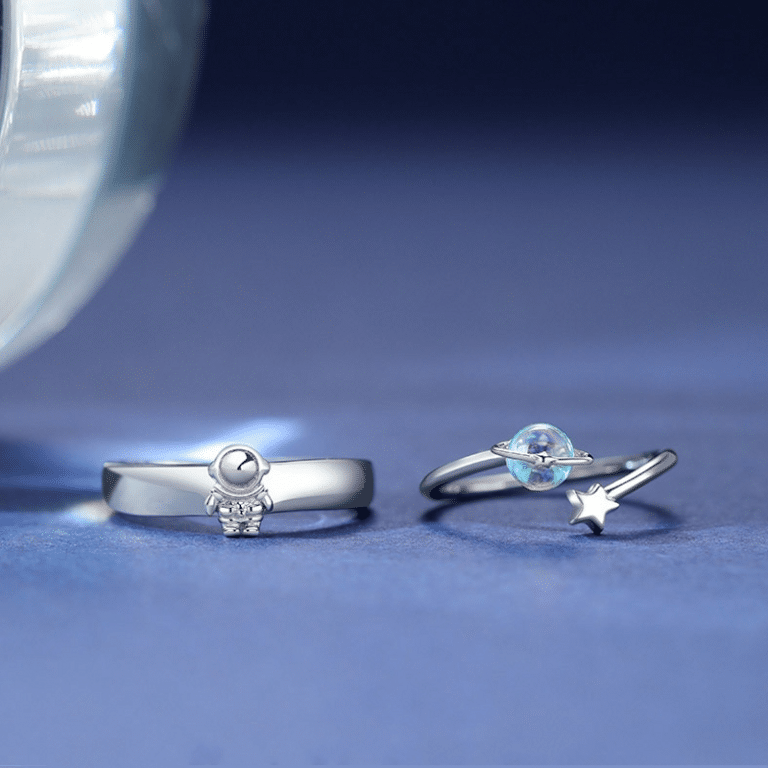 La bague duo astronsom et planet pour couple pour couple devant un arrière plan bleu